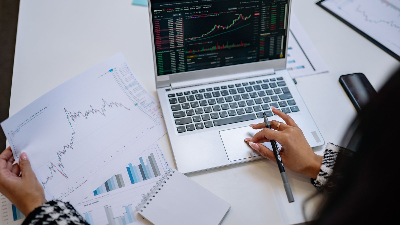 A laptop displaying business charts and forecasting graphs